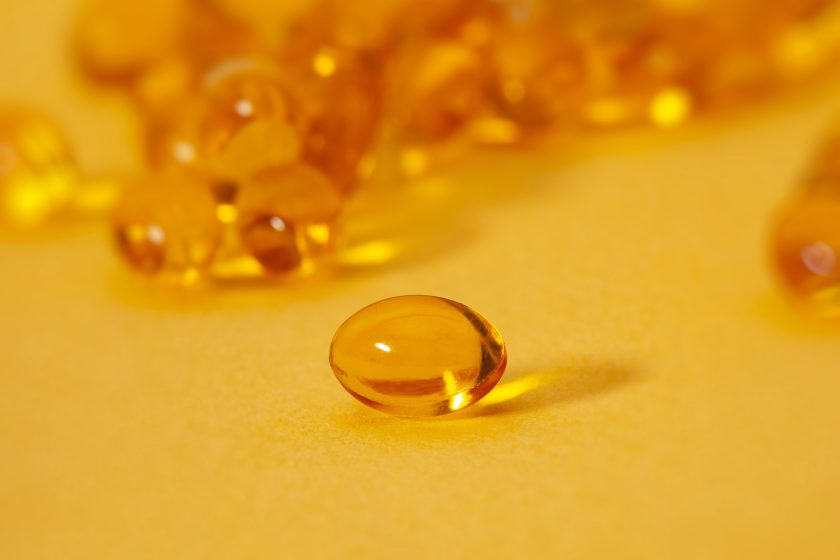 yellow vitamin d capsules on yellow background